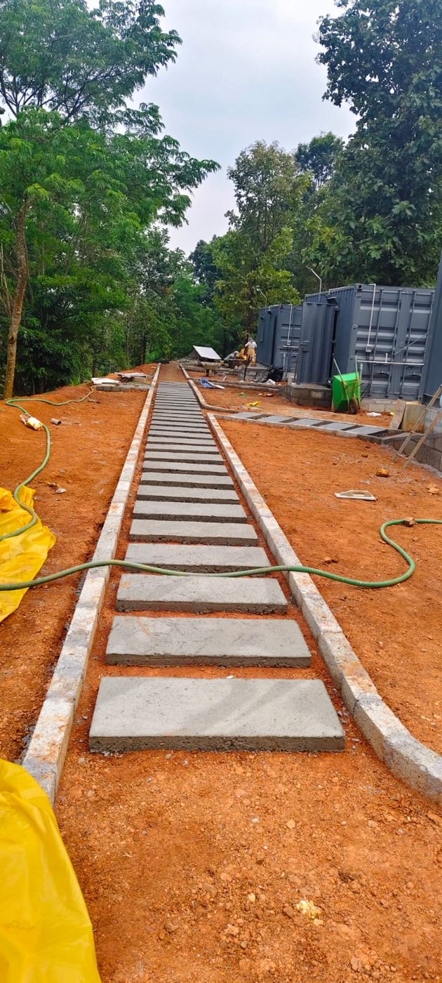 Stone slabs laid as a stepping path along the row of cabins, with forest on both sides